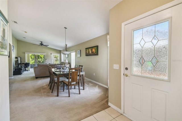 dining room featuring light carpet, lofted ceiling, ceiling fan, and a healthy amount of sunlight