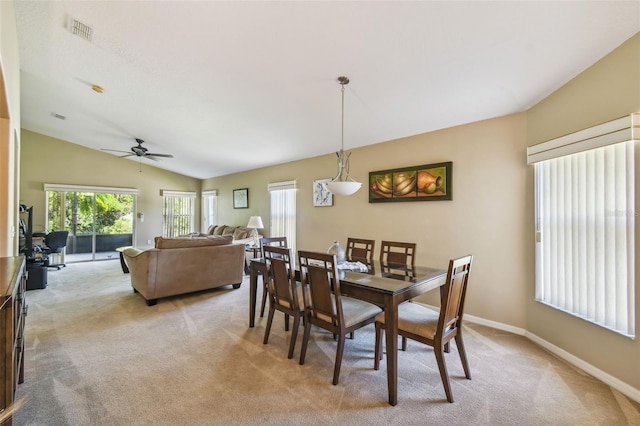 dining space with ceiling fan, lofted ceiling, and light carpet