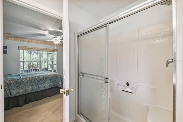 bathroom featuring a textured ceiling, an enclosed shower, and ceiling fan