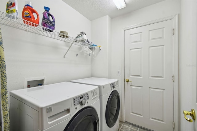 clothes washing area with separate washer and dryer and a textured ceiling