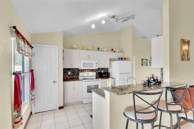 kitchen with white cabinets, white appliances, kitchen peninsula, and light tile patterned floors