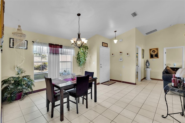 tiled dining area featuring a notable chandelier and lofted ceiling