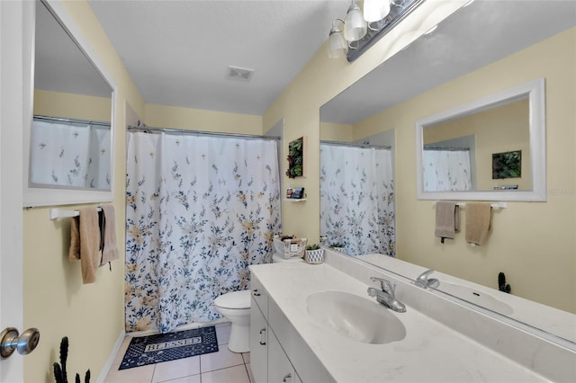 bathroom with toilet, vanity, tile patterned floors, and curtained shower