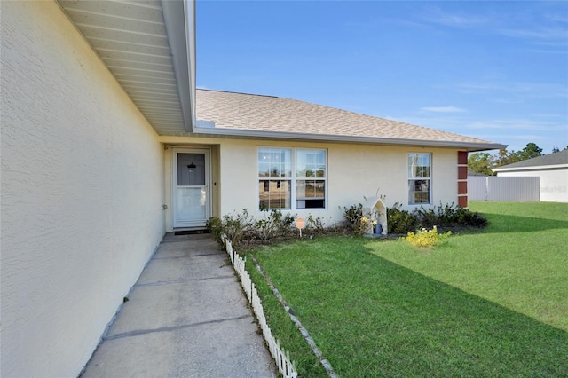 doorway to property featuring a lawn