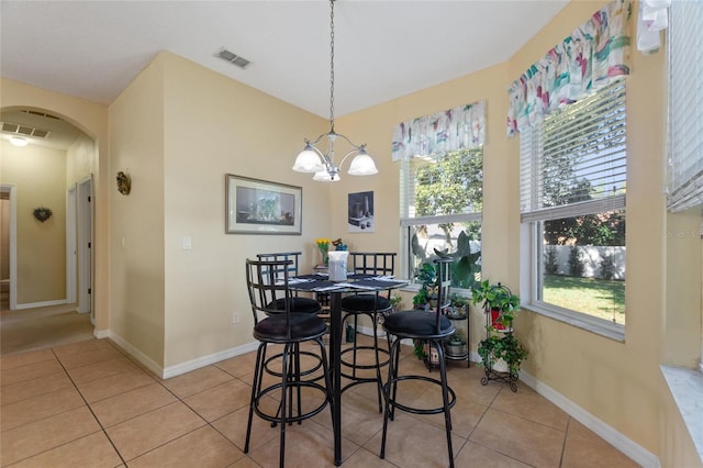 tiled dining space featuring a chandelier