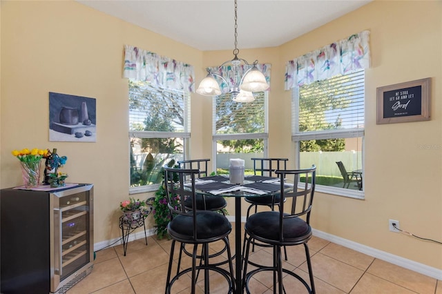 tiled dining room featuring a chandelier and beverage cooler