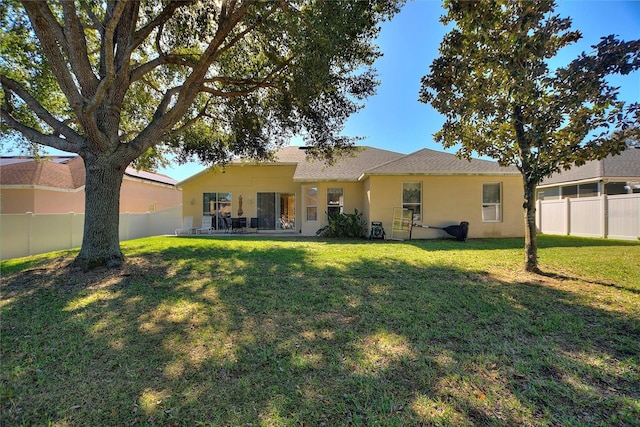 rear view of property with a yard