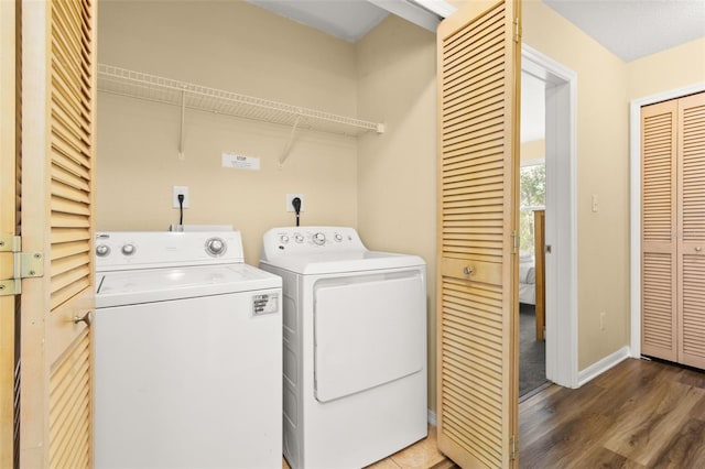 washroom featuring washer and clothes dryer and wood-type flooring