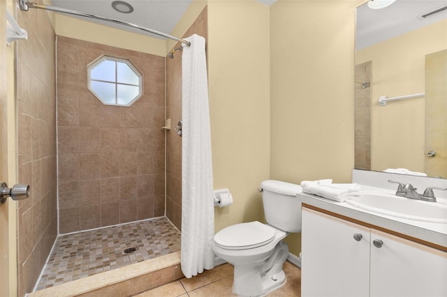 bathroom with toilet, vanity, tile patterned floors, and curtained shower