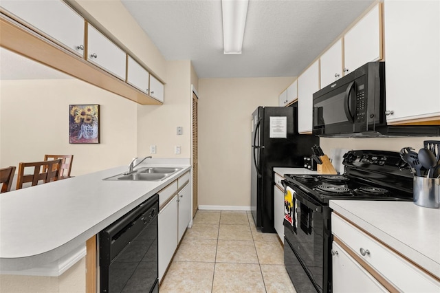 kitchen featuring white cabinets, light countertops, a sink, and black appliances