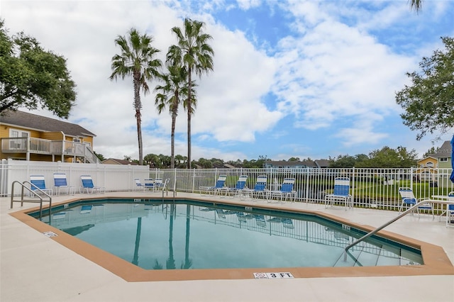 pool with a patio and fence