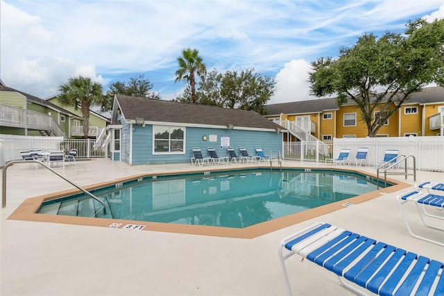 pool with a patio and fence