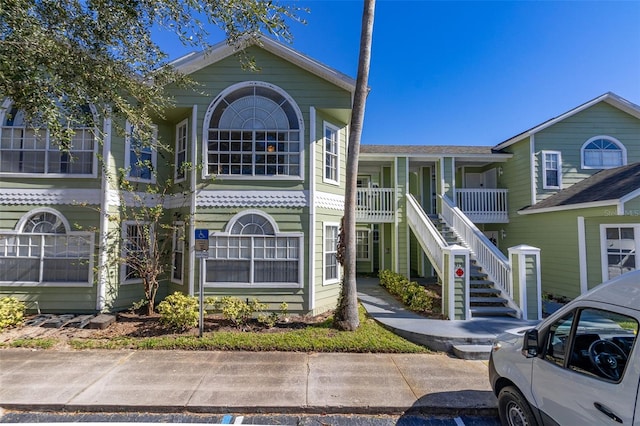 view of front of home featuring covered porch and stairs