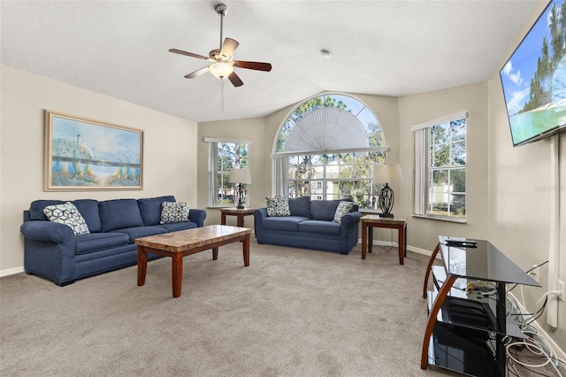 living room with ceiling fan, light colored carpet, a healthy amount of sunlight, and lofted ceiling