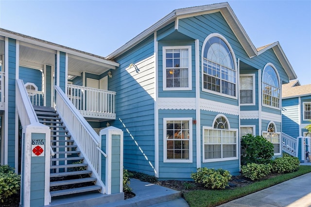 view of property exterior featuring covered porch and stairs