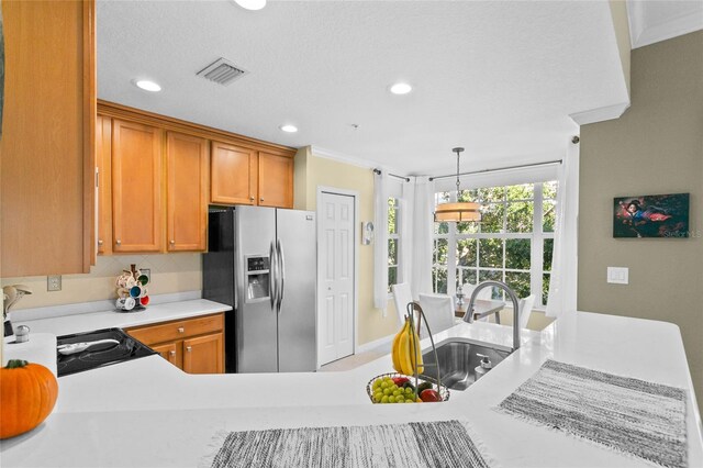 kitchen featuring stainless steel refrigerator with ice dispenser, a textured ceiling, pendant lighting, and sink