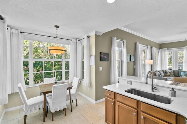 kitchen featuring a textured ceiling, hanging light fixtures, sink, and a wealth of natural light