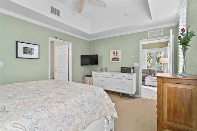 bedroom featuring a raised ceiling, ceiling fan, light colored carpet, and ornamental molding