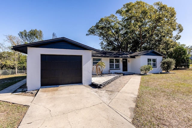 ranch-style home with a front lawn and a garage