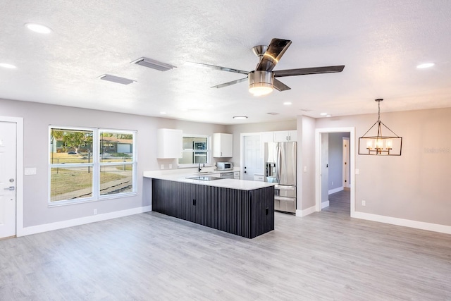 kitchen with pendant lighting, white cabinets, stainless steel refrigerator with ice dispenser, light hardwood / wood-style floors, and kitchen peninsula