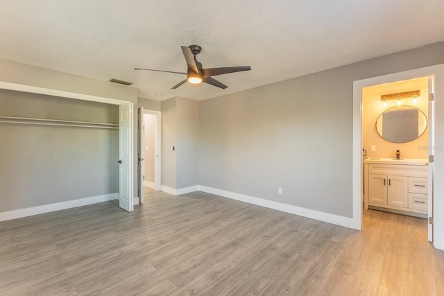 1627 Providence Blvd, Deltona, FL 32725 - unfurnished bedroom featuring light wood-type flooring, a closet, ensuite bathroom, and a ceiling fan