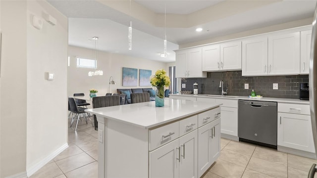 kitchen with white cabinetry, sink, hanging light fixtures, stainless steel dishwasher, and light tile patterned floors