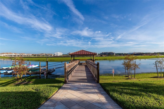 view of dock featuring a gazebo, a lawn, and a water view