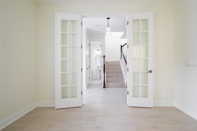 corridor with french doors and light hardwood / wood-style floors