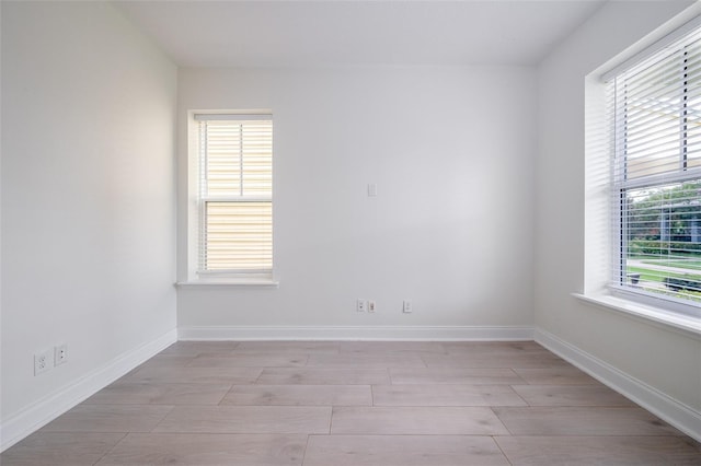 unfurnished room featuring plenty of natural light and light hardwood / wood-style floors