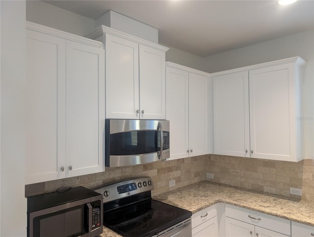 kitchen with light stone counters, appliances with stainless steel finishes, decorative backsplash, and white cabinetry