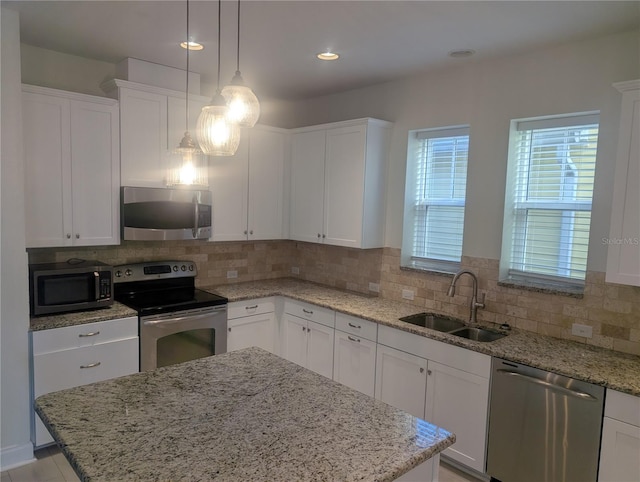 kitchen featuring a sink, appliances with stainless steel finishes, decorative backsplash, and white cabinetry