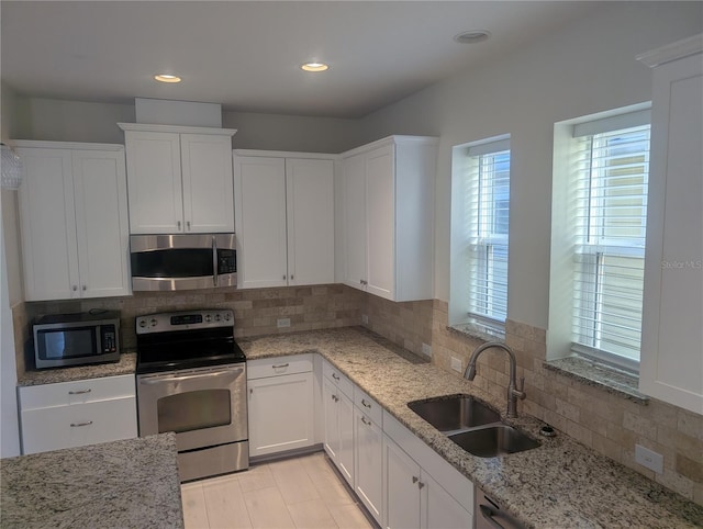 kitchen featuring a sink, appliances with stainless steel finishes, backsplash, and white cabinets