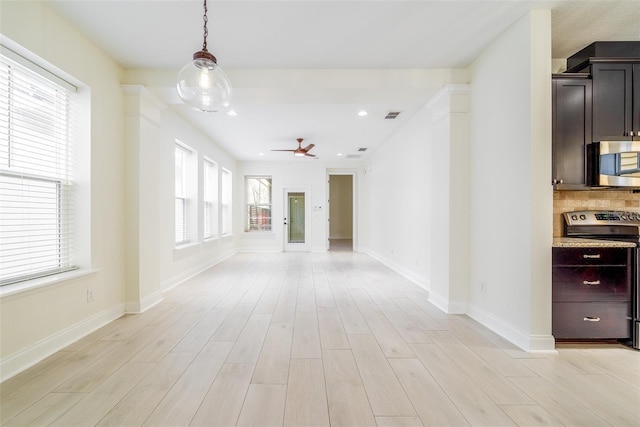 interior space with baseboards, ceiling fan, light wood-type flooring, and visible vents