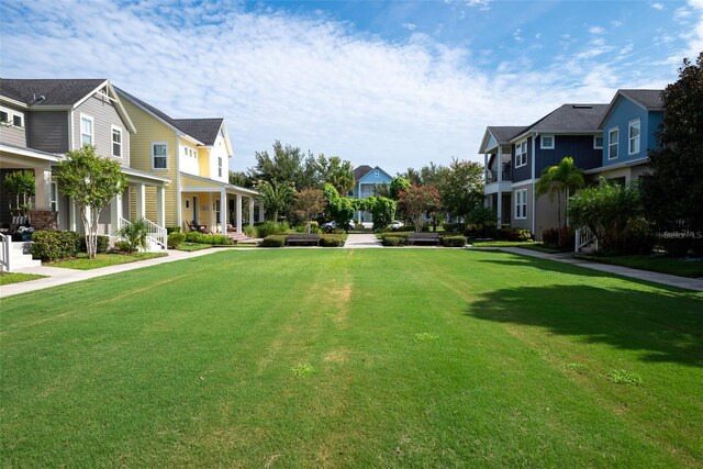 view of yard with covered porch and a residential view
