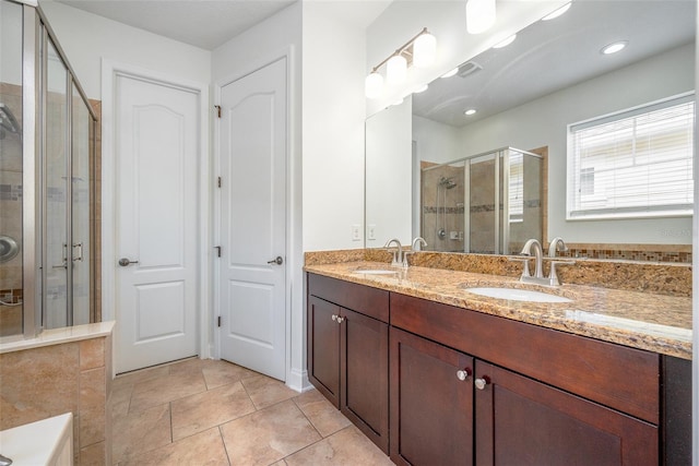 bathroom with double vanity, a sink, tile patterned flooring, and a shower stall