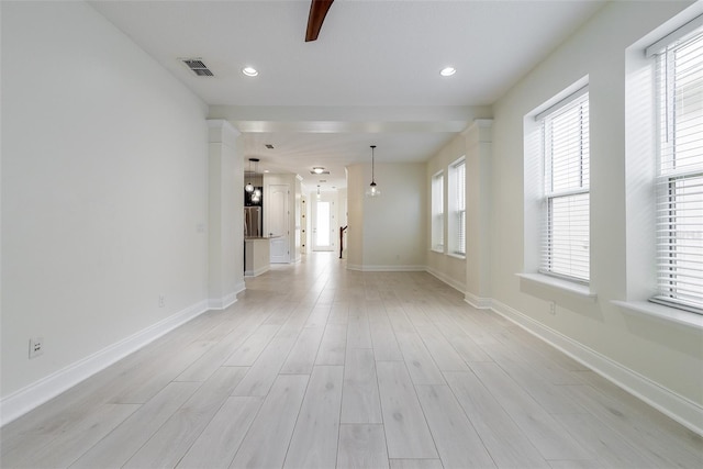 empty room featuring baseboards, light wood-type flooring, and visible vents