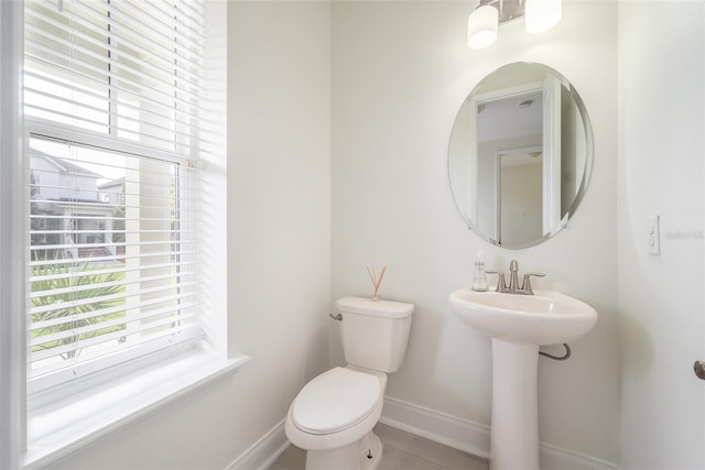bathroom featuring baseboards, a wealth of natural light, and toilet