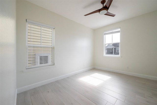 spare room with baseboards, a ceiling fan, and light wood finished floors