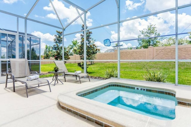 view of pool featuring an outdoor hot tub, glass enclosure, a yard, and a patio