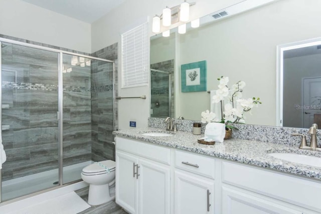 bathroom featuring vanity, toilet, and a shower with door