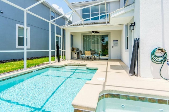 view of pool featuring glass enclosure, ceiling fan, and a patio