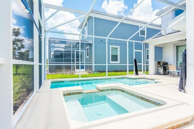 view of swimming pool with a lanai, a patio area, an in ground hot tub, and grilling area