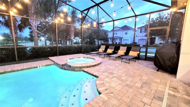 view of pool featuring glass enclosure, an in ground hot tub, a grill, and a patio