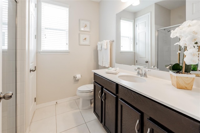 bathroom with a wealth of natural light, tile patterned floors, vanity, and toilet