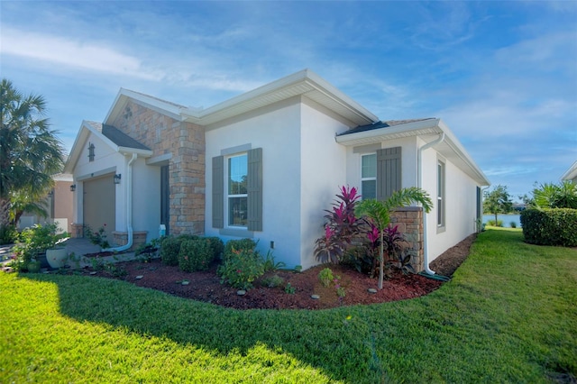 view of side of property with a garage and a lawn