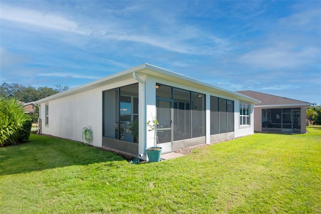 back of house featuring a sunroom and a yard