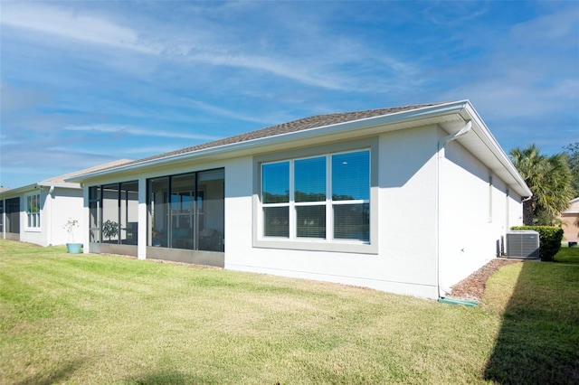 back of house with a yard and central air condition unit