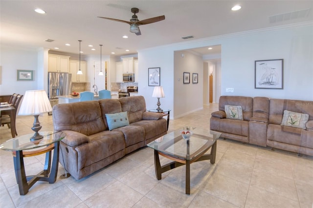 tiled living room with ceiling fan, ornamental molding, and sink