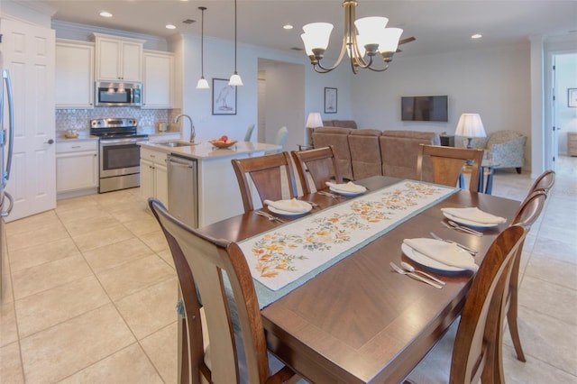 tiled dining room featuring sink, ornamental molding, and an inviting chandelier