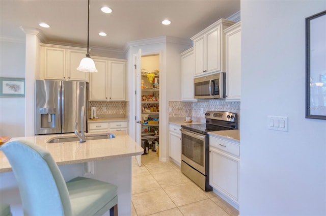 kitchen featuring sink, hanging light fixtures, light tile patterned floors, light stone counters, and stainless steel appliances